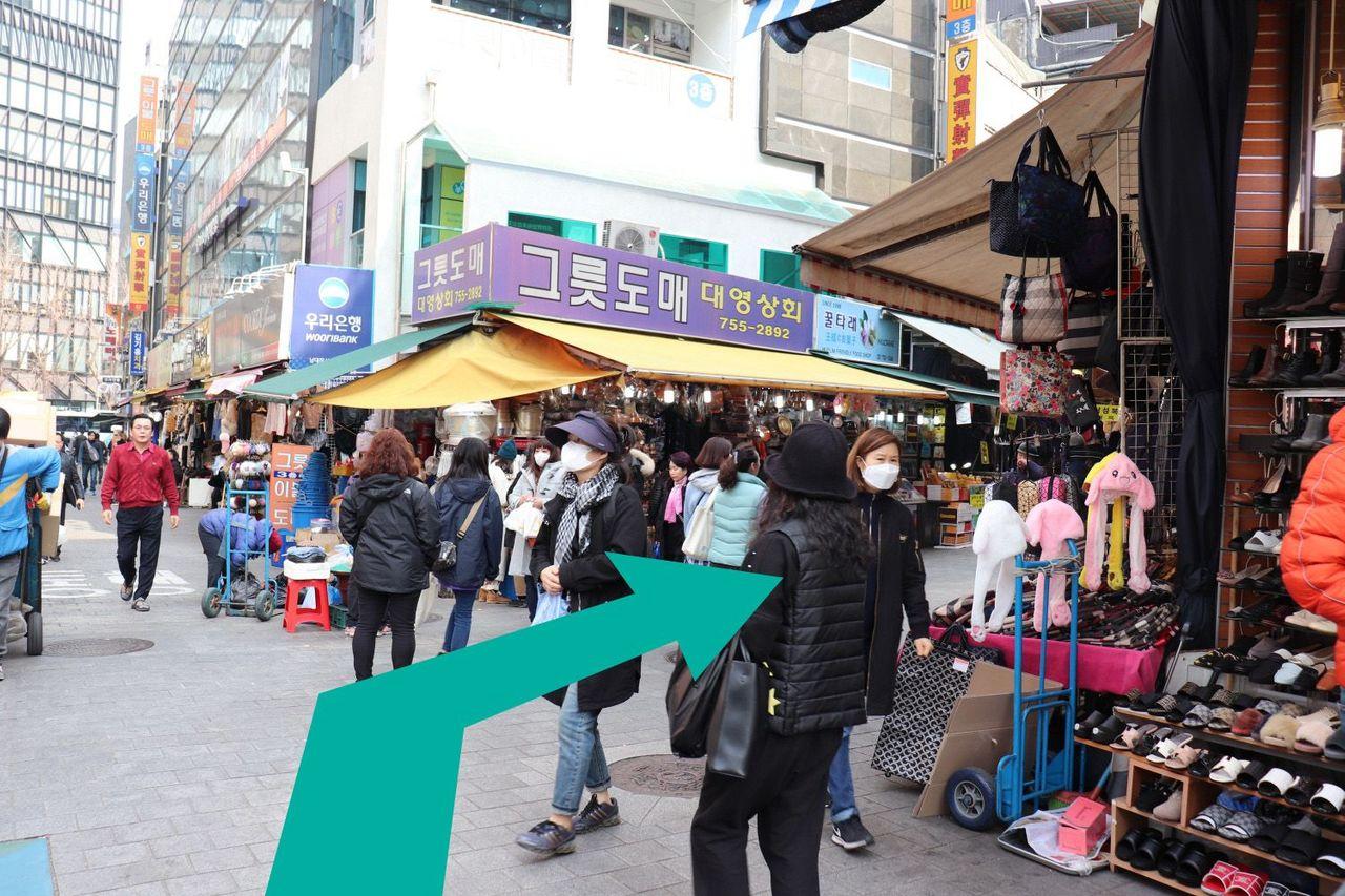 Street filled with shoppers and view of landmarks leading to Namdaemun Market's Jangan Store.